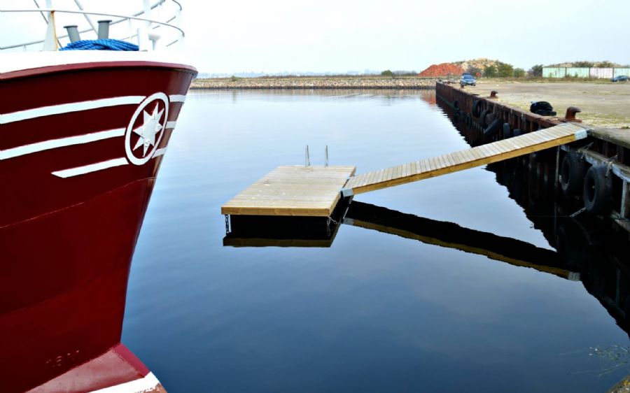 Spejlblank havn med rødt skib